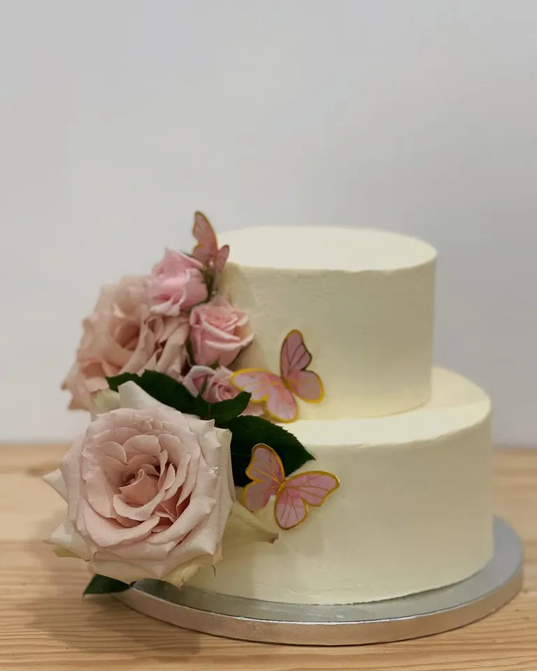 Tarta de dos pisos con rosas y mariposas para una comunión
